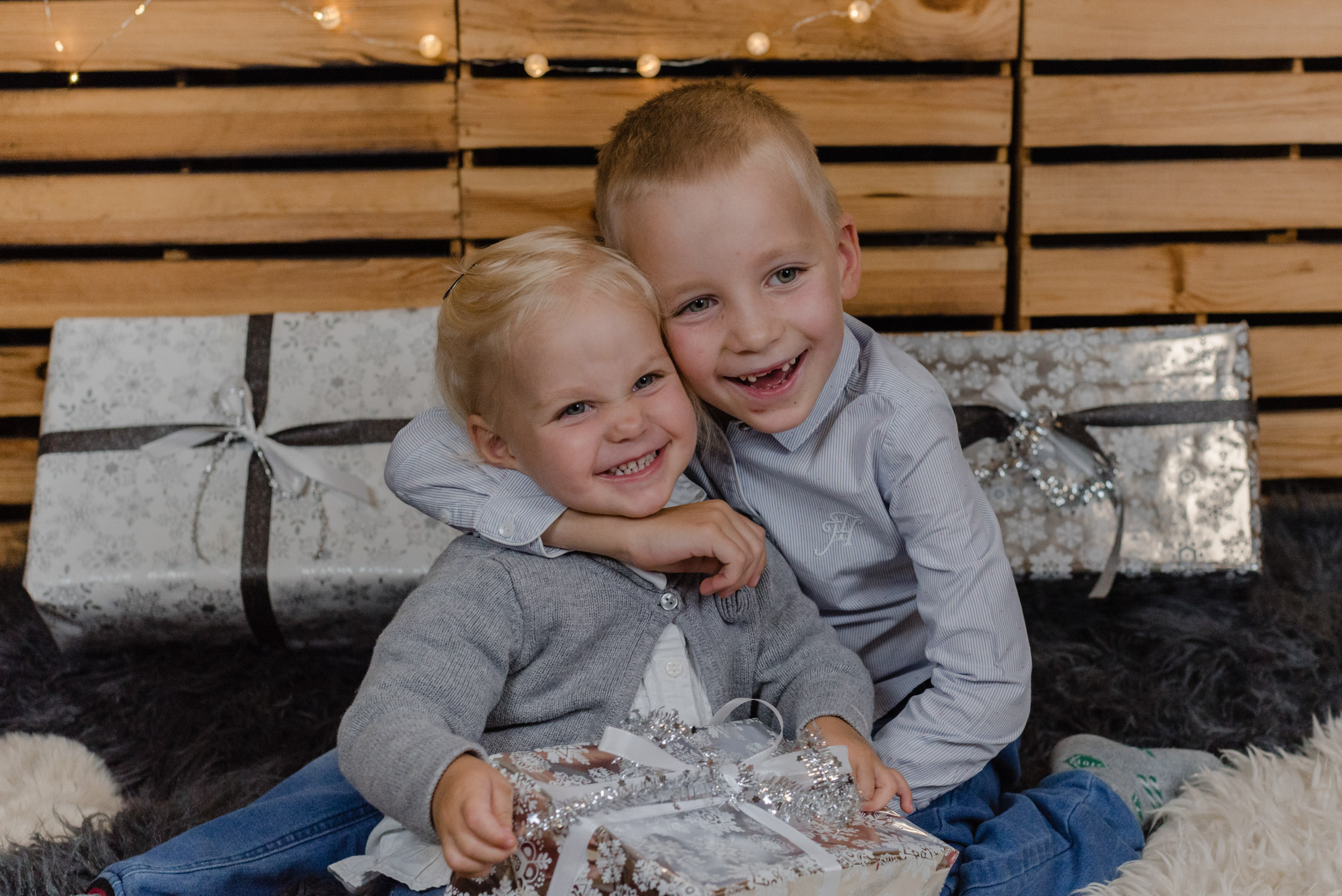 Zwei Geschwister lachen beim Weihnachtsshooting – Janina Haner Photography