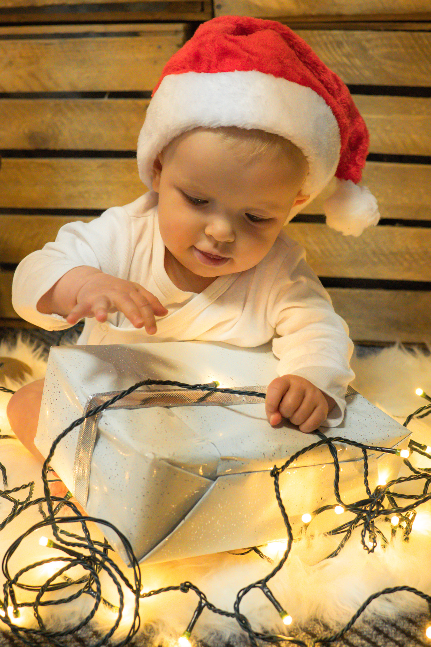 Kind mit Nikolausmütze und Lichterkette beim Weihnachtsshooting – Janina Haner Photography